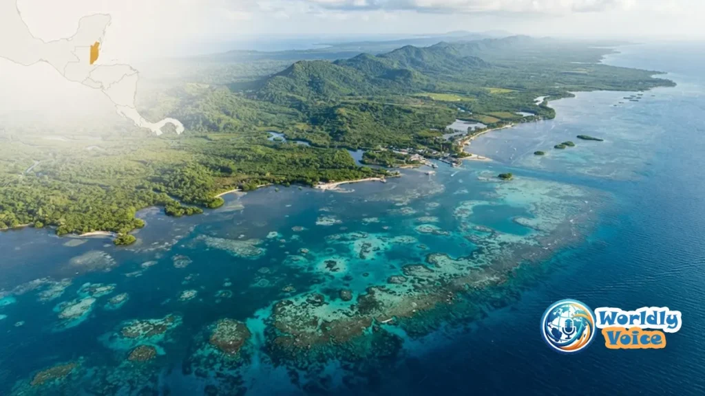 Where Is Belize Located? Map, Borders & Country Guide 2026 Aerial view of Belize showing Caribbean coastline, tropical cayes, and mainland jungle with a subtle Central America map overlay.